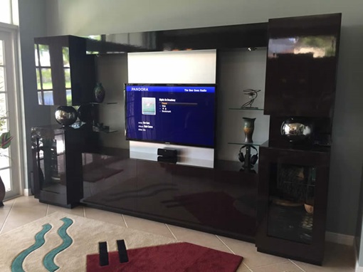 A flat-screen TV mounted on a stylish entertainment center in a living room in Martin County.