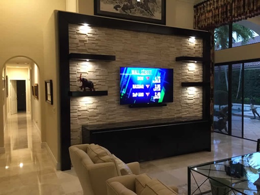 A flat-screen TV mounted on a stylish entertainment unit in a living room in Broward County.